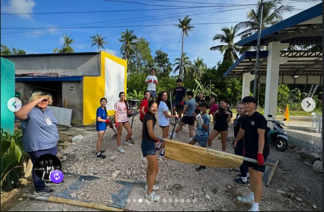 Students carrying building materials during a village work day